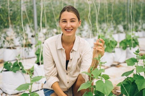 A woman with her plants inside a greenhouse