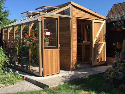 Alton Fusion cedar greenhouse with a warm Western Red Cedar frame set in a landscaped garden