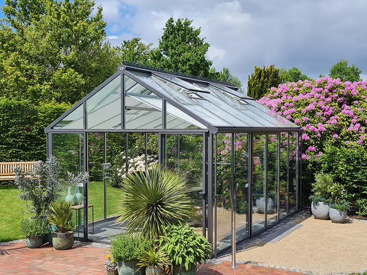 Modern glass greenhouse installed on a level foundation with integrated ventilation and access paths
