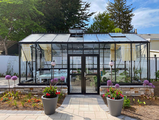  A spacious glass greenhouse with outdoor seating, showing how a larger structure supports long-term gardening expansion.