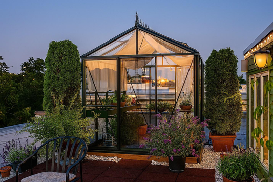 Royal Victorian glass greenhouse illuminated at dusk, highlighting its insulated panels and energy-efficient design.