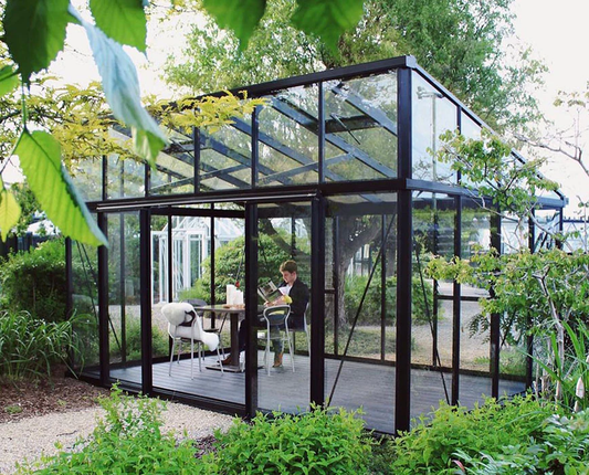 Modern glass greenhouse with full-height glazing designed for light transmission and climate-controlled growing