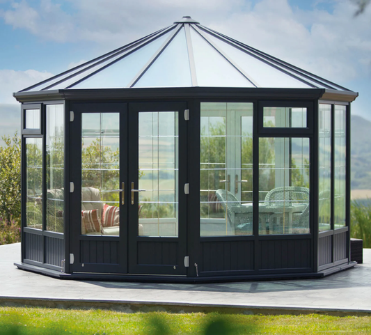  A glass garden room with seating overlooking mountains 