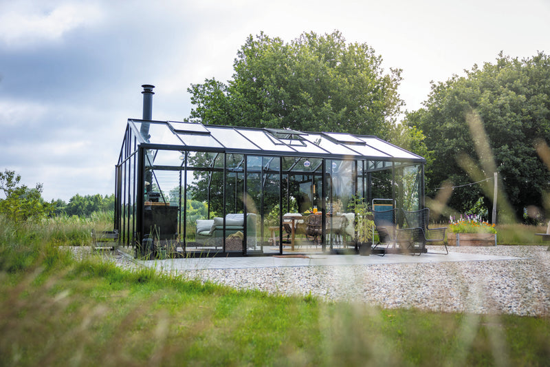 Larger model shown – Exaco Janssens glass greenhouse garden room on a gravel pad
