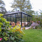 Exaco Janssens Pyramid glass greenhouse with a four-sided pyramid roof in a garden