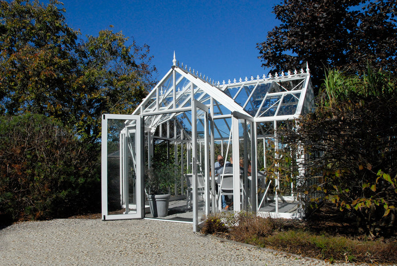 White EOS T-shaped greenhouse in a landscaped garden