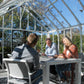 People seated at a table inside the EOS Royal Antique Victorian greenhouse