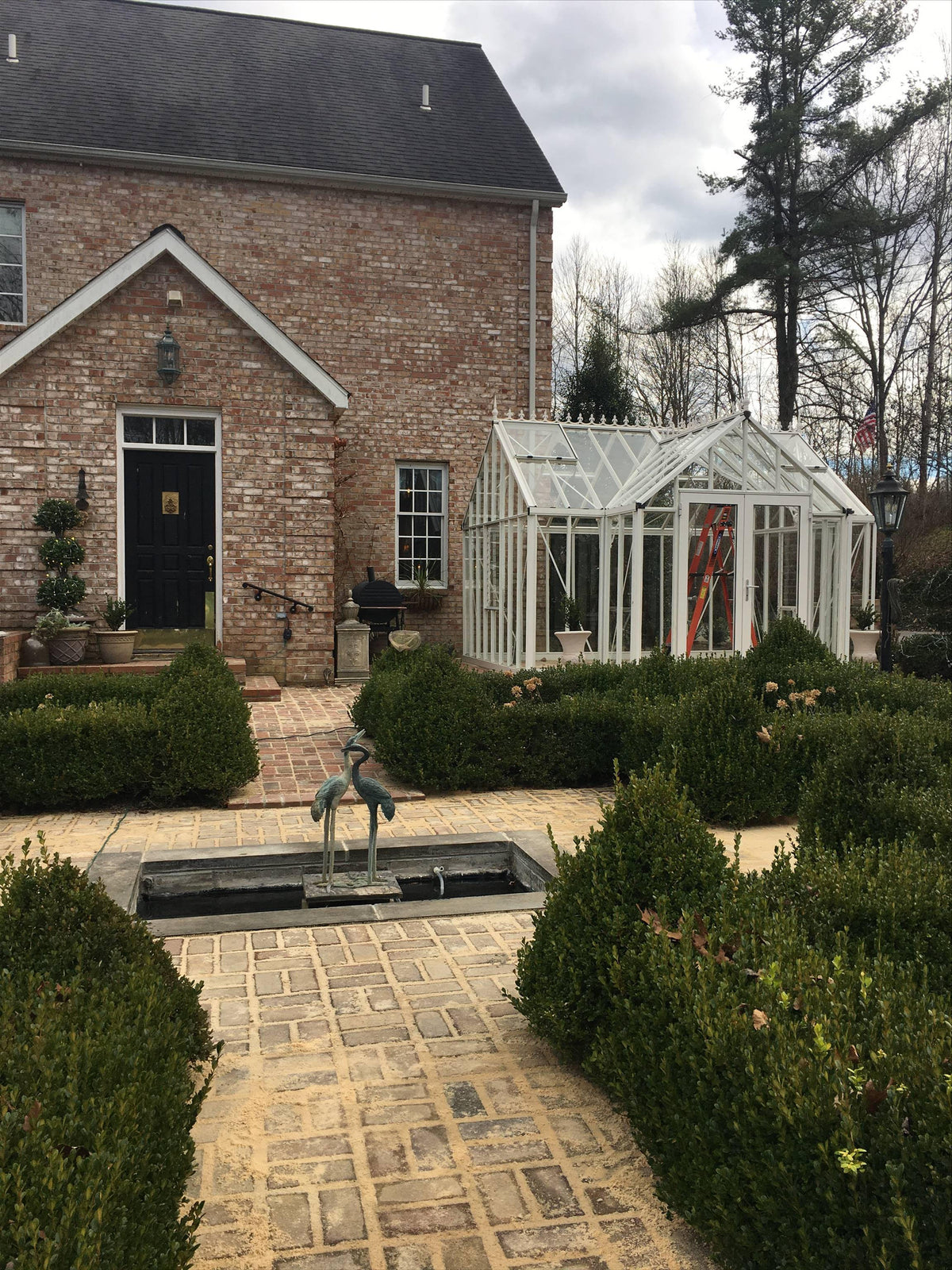 EOS Royal Antique Victorian greenhouse in front of a brick manor house