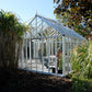 Side view of the EOS Royal Antique Victorian greenhouse among ornamental grasses