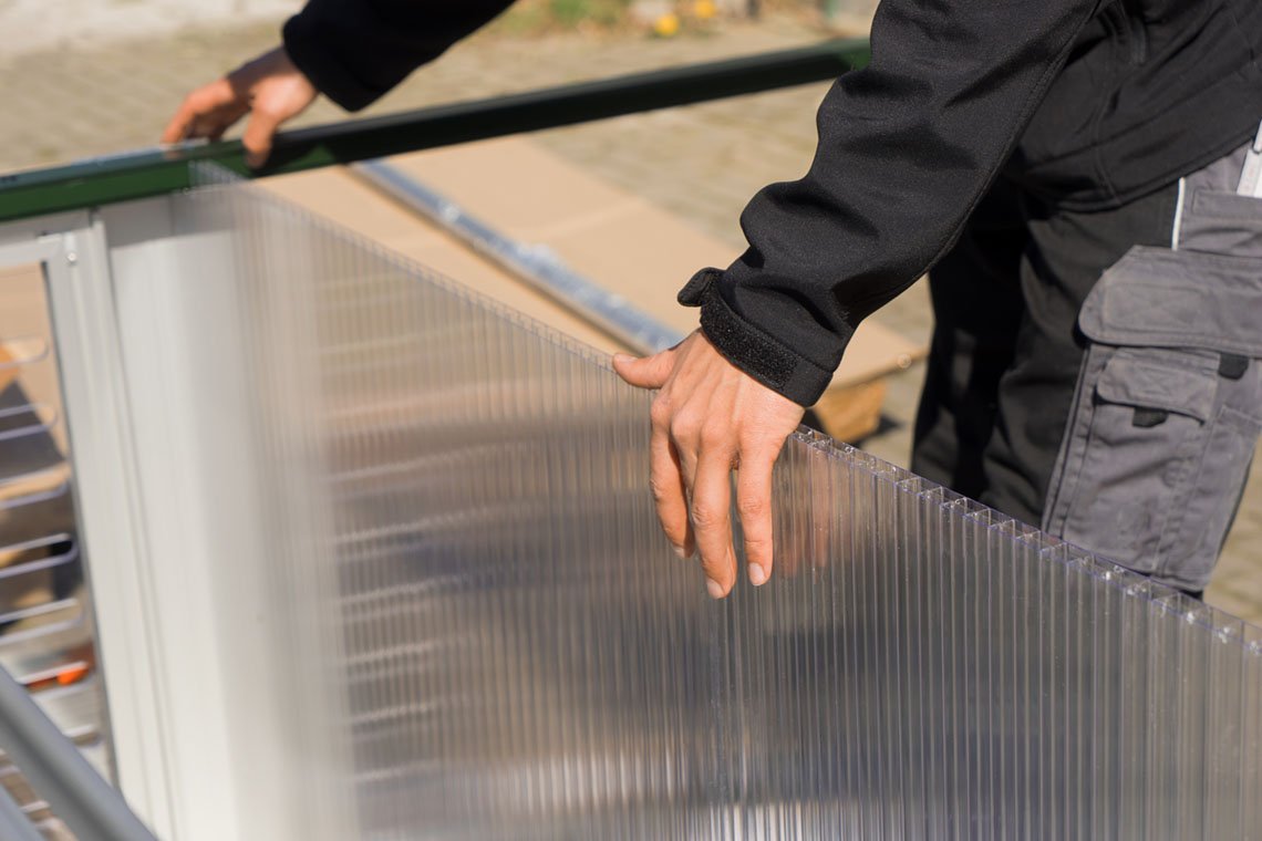 Close-up of a Hoklartherm multi-wall polycarbonate panel being fitted into the aluminum frame