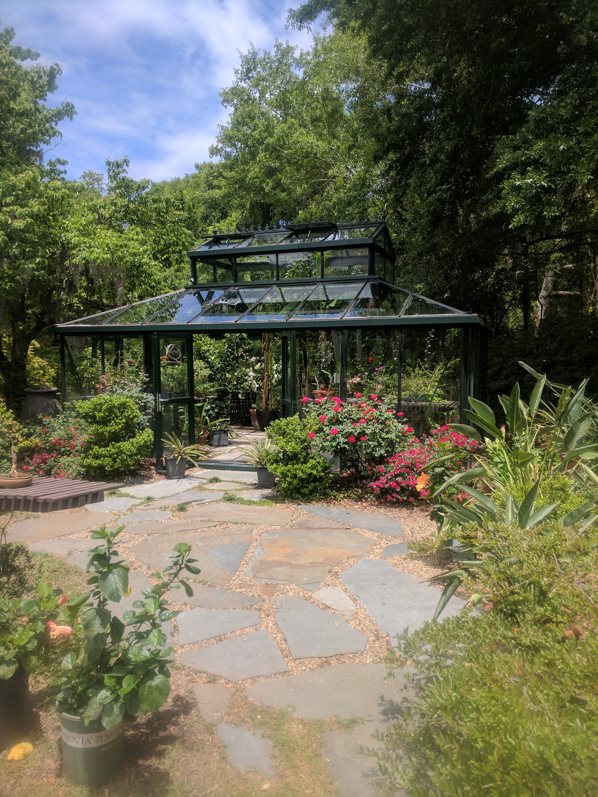 Cathedral Victorian Orangerie with raised lantern roof beside a garden path