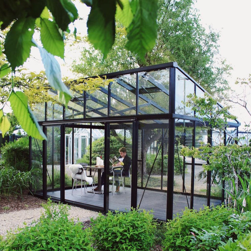 Janssens Modern greenhouse in a garden setting (10x15 M34 shown)