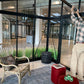 Inside a Janssens Modern greenhouse with seating and plants