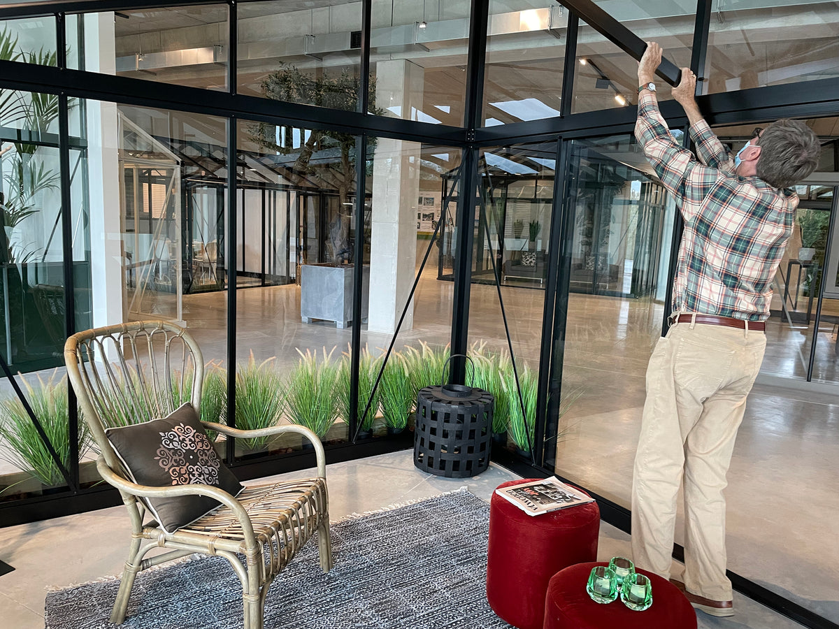 Inside a Janssens Modern greenhouse with seating and plants
