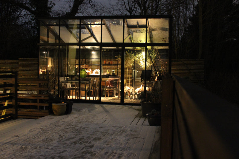 Janssens Modern greenhouse lit up at night (10x15 M34 shown)