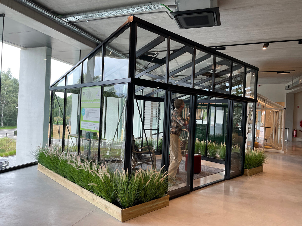 Larger model shown – Exaco Janssens Modern M34 greenhouse in a showroom