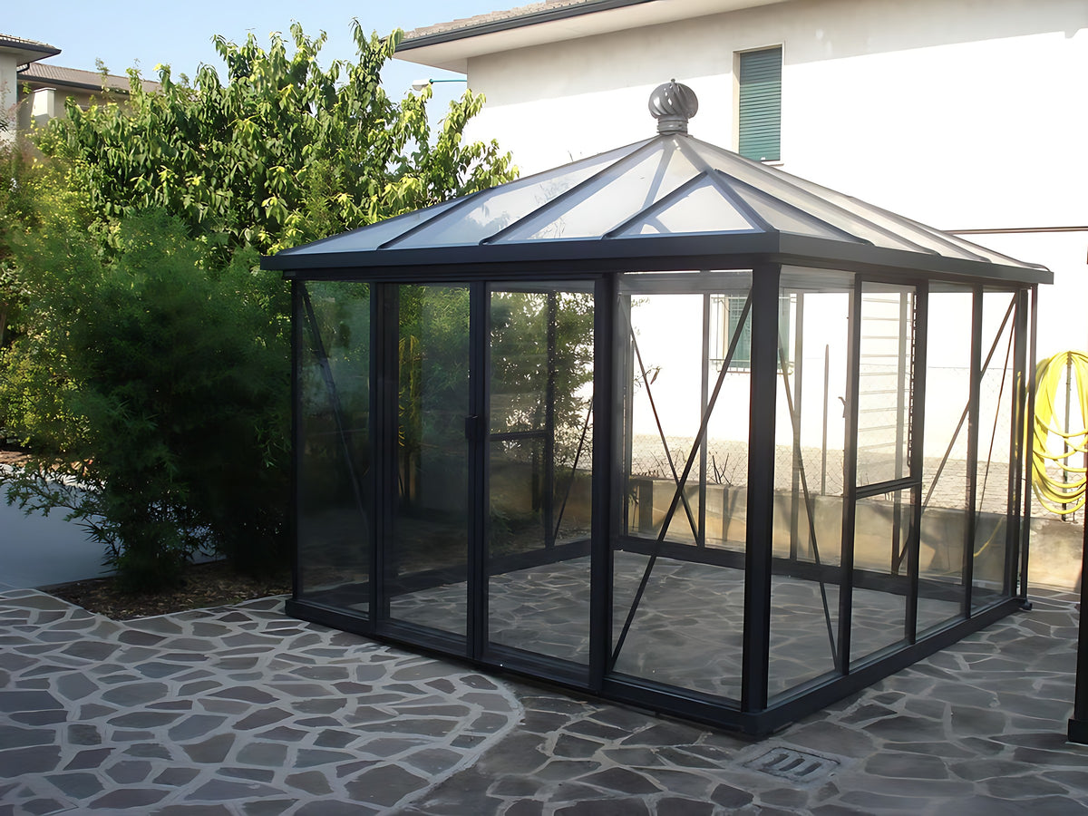 Janssens Pyramid glass greenhouse on a stone patio with roof vent and double sliding doors