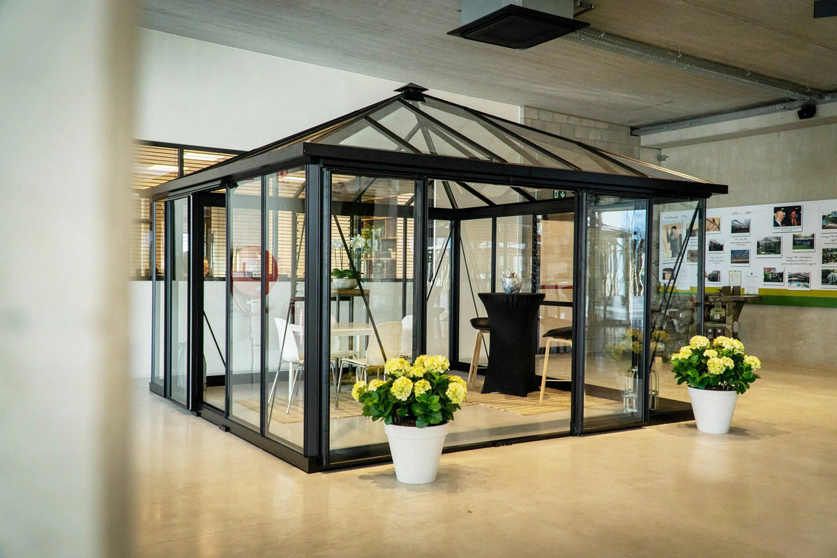 Janssens Pyramid glass greenhouse with black frame set up as a glass room in the Janssens showroom