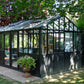 Janssens Retro Royal Victorian glass greenhouse in black, set in a landscaped garden