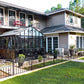 Black Retro Royal Victorian greenhouse in a home garden beside the house