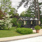 Retro Royal Victorian black aluminum greenhouse on a garden lawn