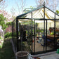 Larger model shown – Exaco Janssens Royal Victorian glass greenhouse in a garden with shade curtains