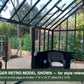 Seating area inside a black Janssens Retro Victorian greenhouse – larger Retro model shown for style reference; the Retro 23 is 7'9" x 10'2"