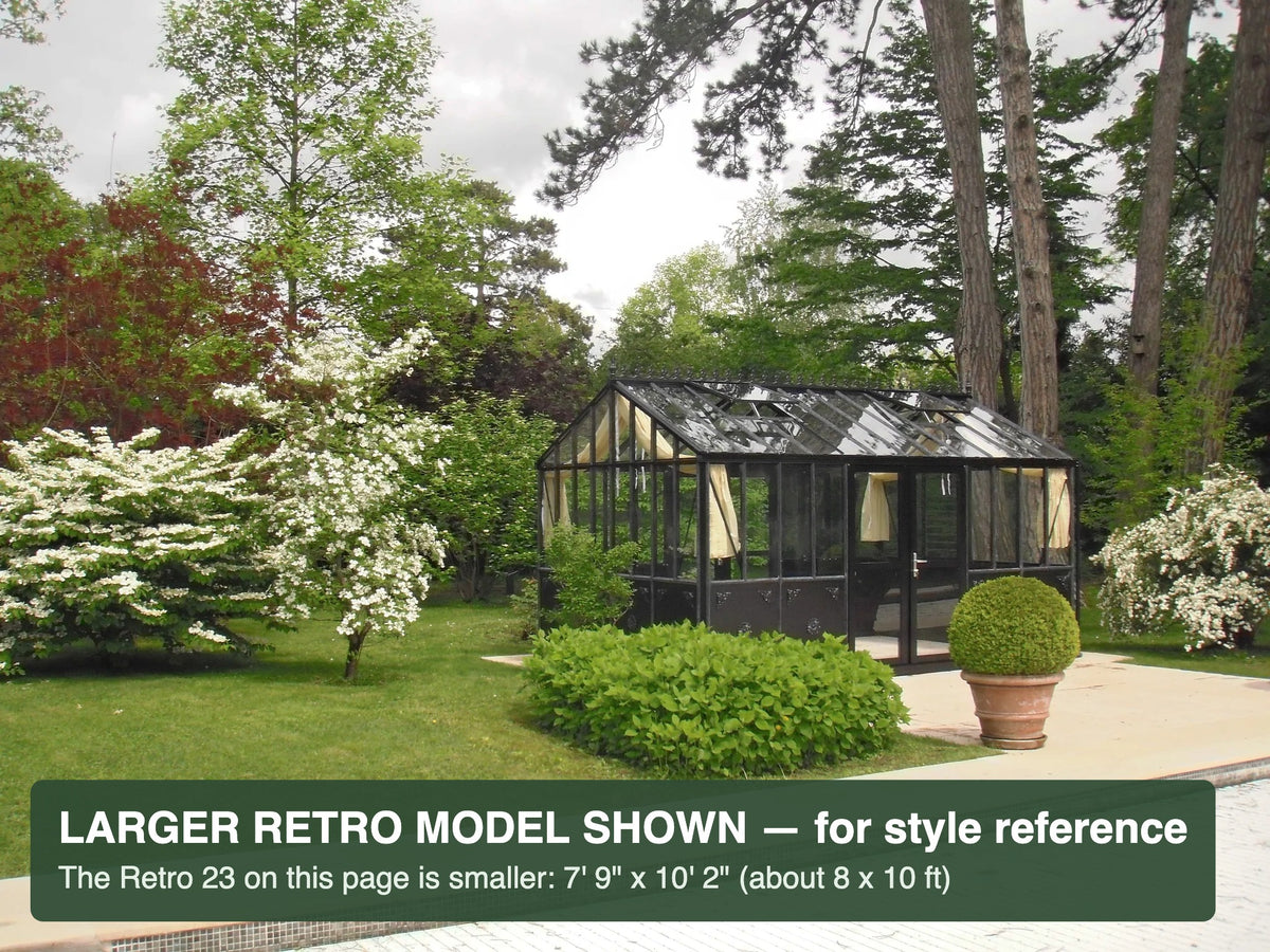 Black Janssens Retro Victorian greenhouse on a garden lawn – larger Retro model shown for style reference; the Retro 23 is 7'9" x 10'2"