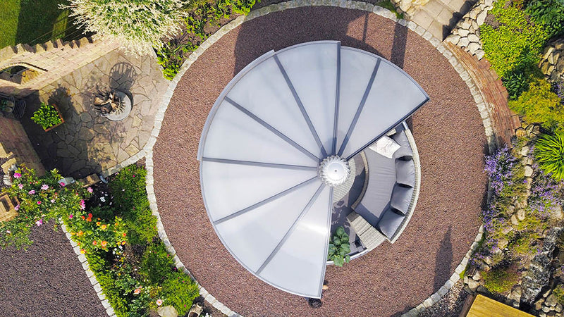 Aerial view of the Rondo pavilion showing its round roof and circular base in a landscaped garden