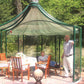 Green-frame Rondo pavilion with pyramid roof and walls rotated open over a patio dining set