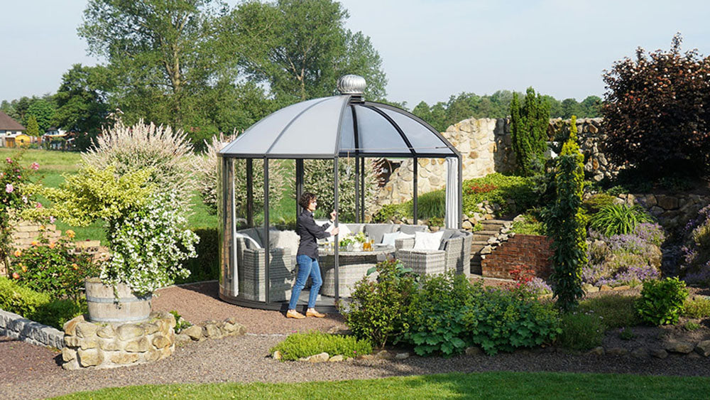 Rondo pavilion with dome roof and walls turned open toward a stone garden