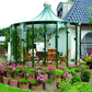 Green-frame Rondo pavilion beside a house surrounded by pink flower beds