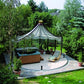 Rondo pavilion covering a hot tub and lounge chair on a round stone patio