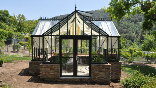 Black Royal T-Shaped Victorian Antique Orangerie on a stone base in a garden