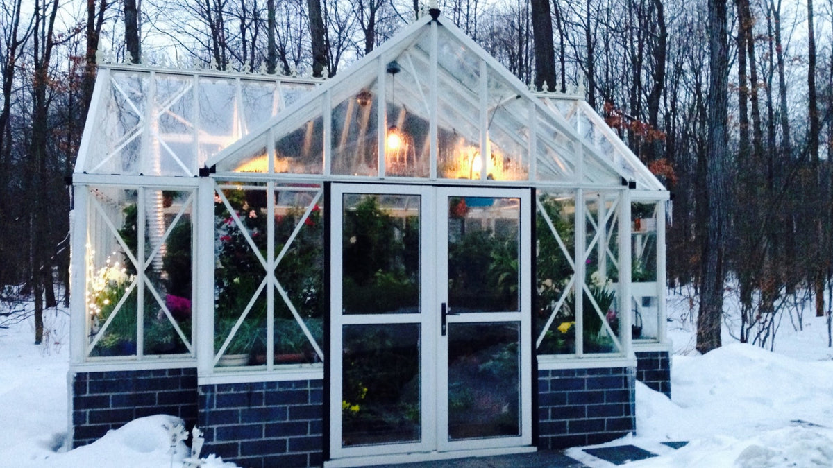 White Royal Antique Orangerie lit up at night in winter snow