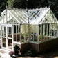 White Royal Antique Orangerie greenhouse in a shaded garden
