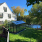 Exaco Janssens Royal Victorian VI36 glass greenhouse in a backyard with the home behind it
