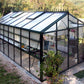 Royal Victorian VI36 glass greenhouse on a gravel base, surrounded by plants