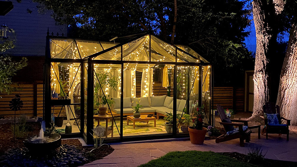 Janssens T-Shaped Royal Victorian Orangerie lit up at night on a patio